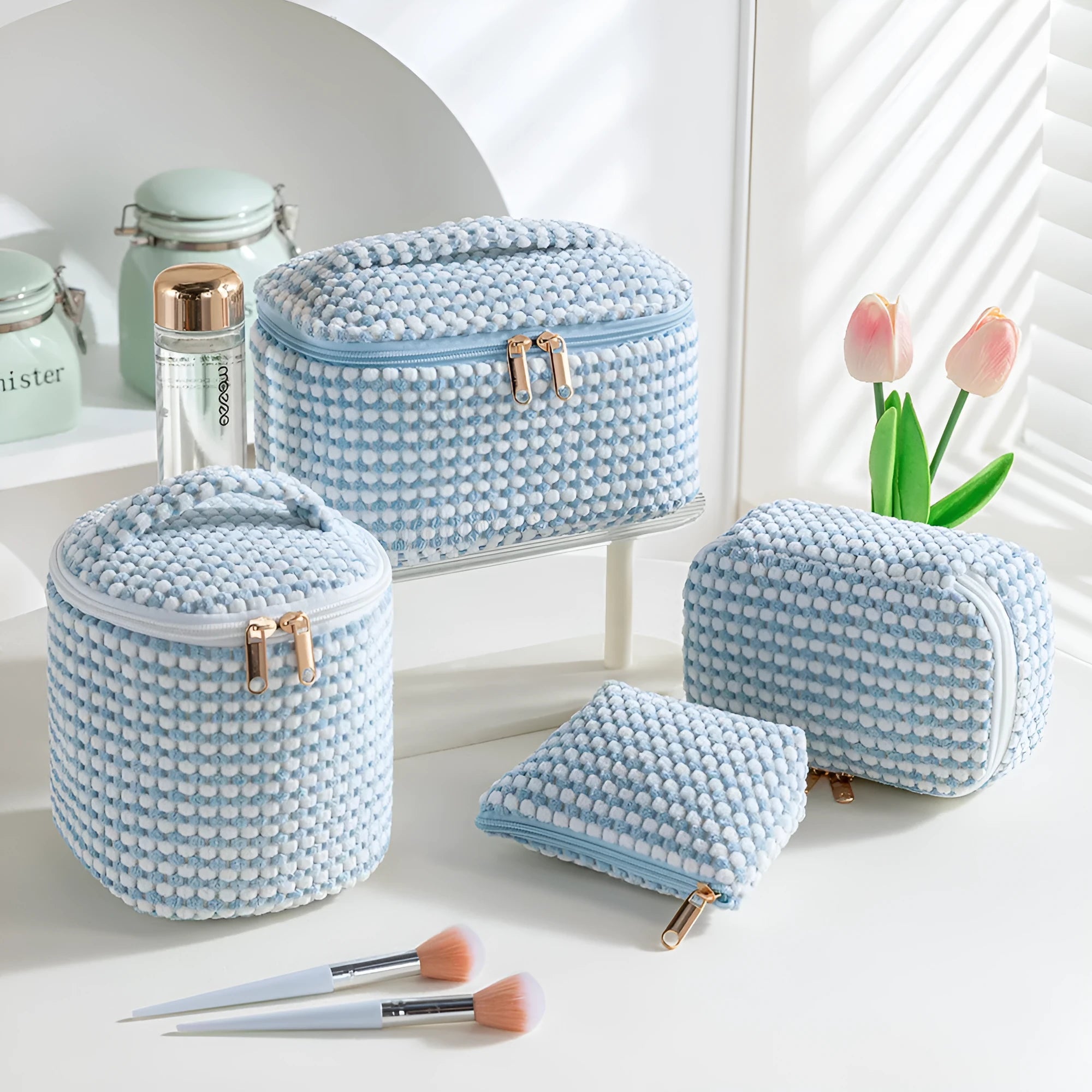Four cube-shaped flannelette makeup bags in coordinated colours for travel organisation