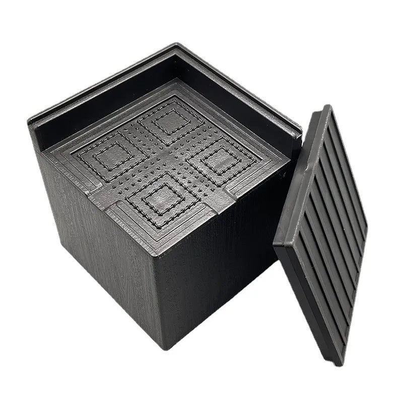 Four black thickened plastic bed foot mats arranged for height increasing furniture support