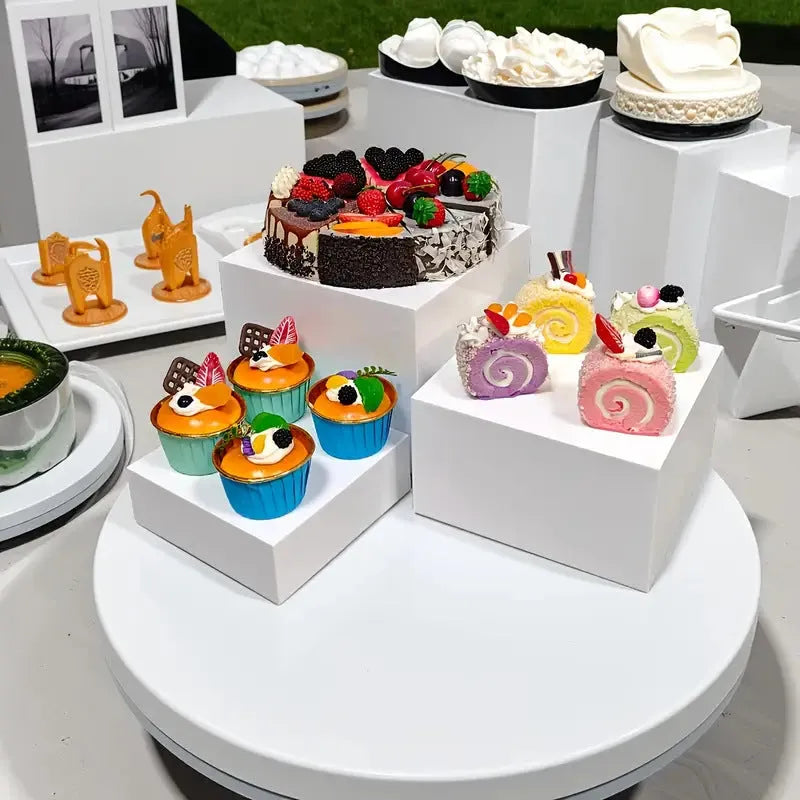 White plastic modular dessert display stand with six interlocking cube pieces arranged in a tiered configuration.