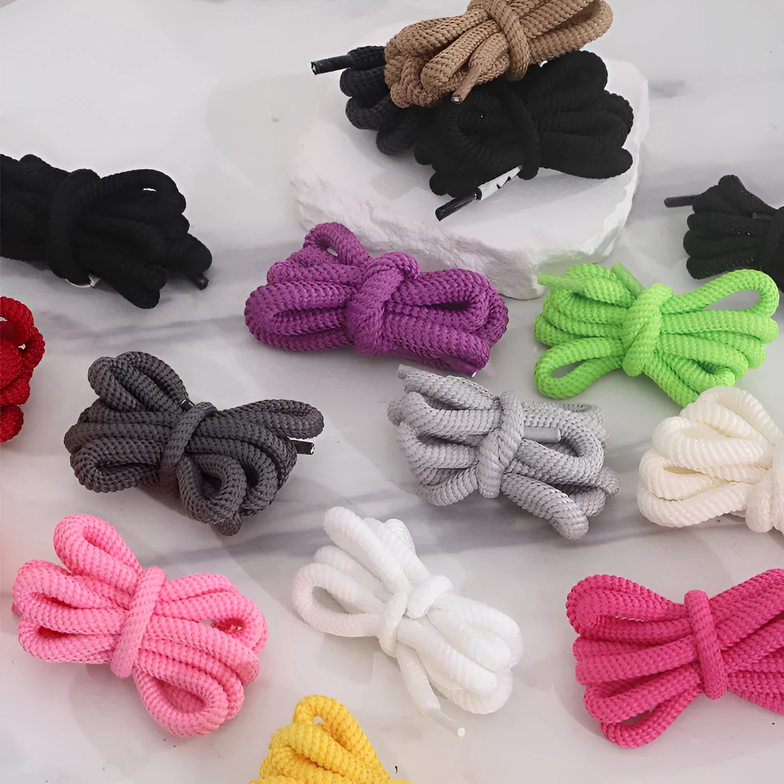 Round 1.0cm wide shoelace adapters in multiple colours including black, pink, blue, and grey on a white background.
