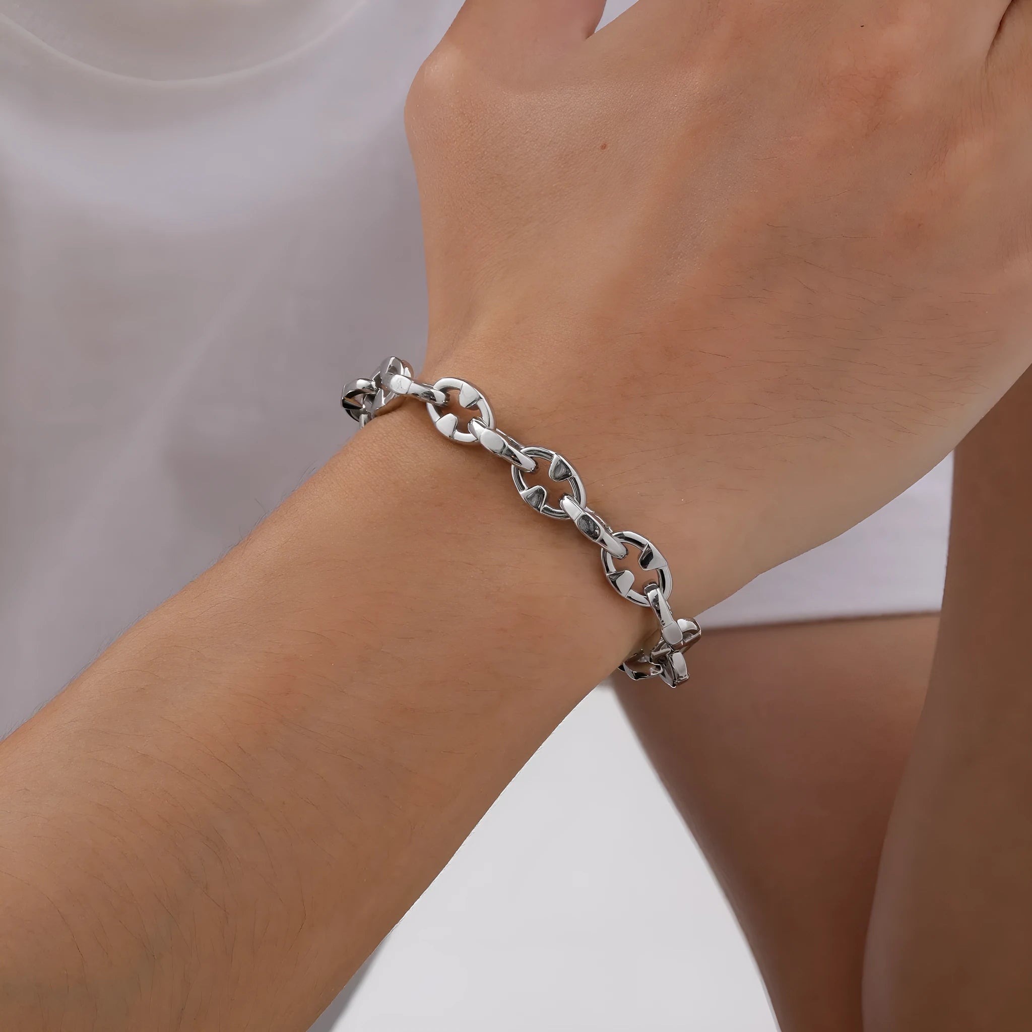 Men's stainless steel handmade geometric chain bracelet in steel colour on a wrist.