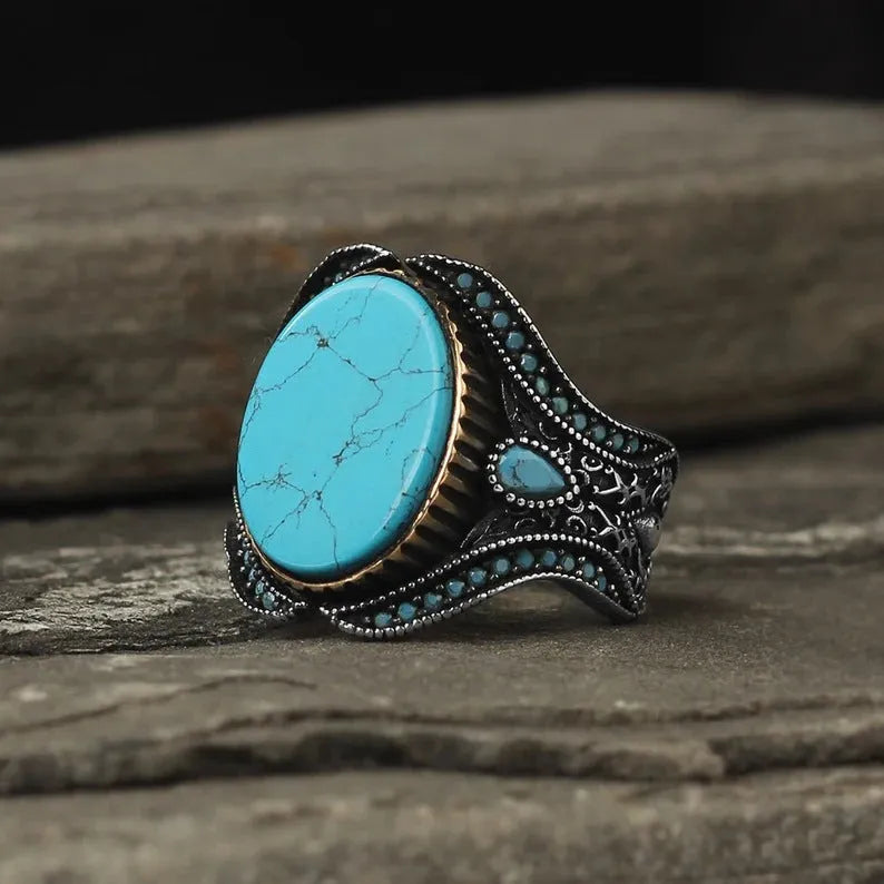 Men's turquoise and antique silver alloy ring on finger showing round band design with UK size markings