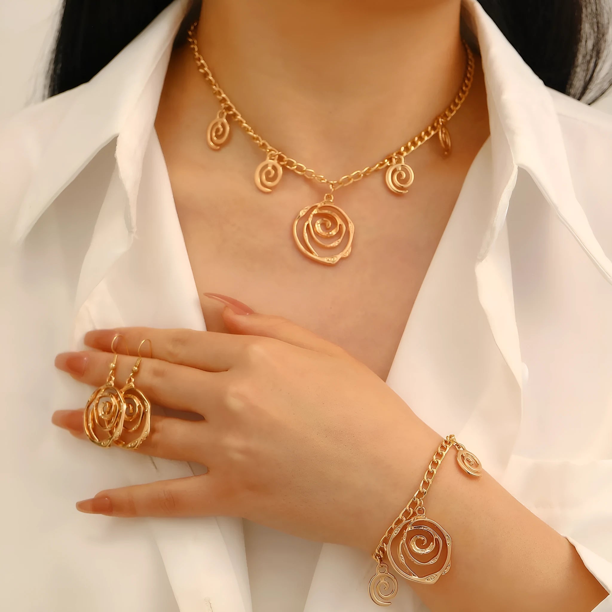 Women's spiral donut jewellery set showing matching gold necklace, bracelet, and earrings with geometric circle design