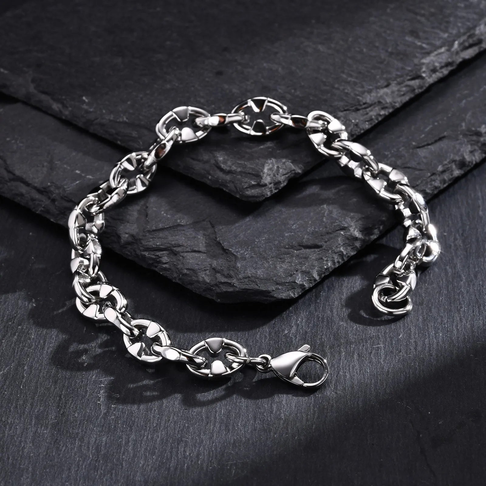Men's stainless steel handmade geometric chain bracelet in steel colour on a wrist.
