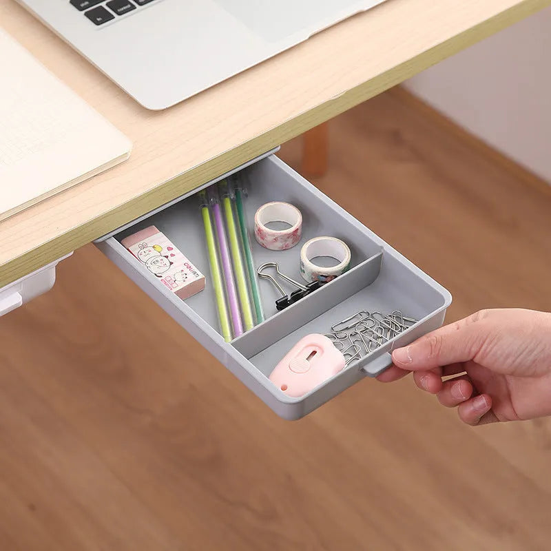 White plastic under-desk storage box with a lid open, showing an internal grid pattern.