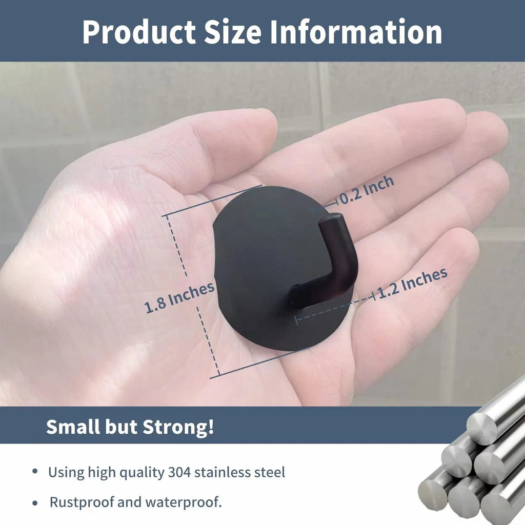 Stainless steel self-adhesive wall hook in black and polished finishes, shown with a towel hanging from it.