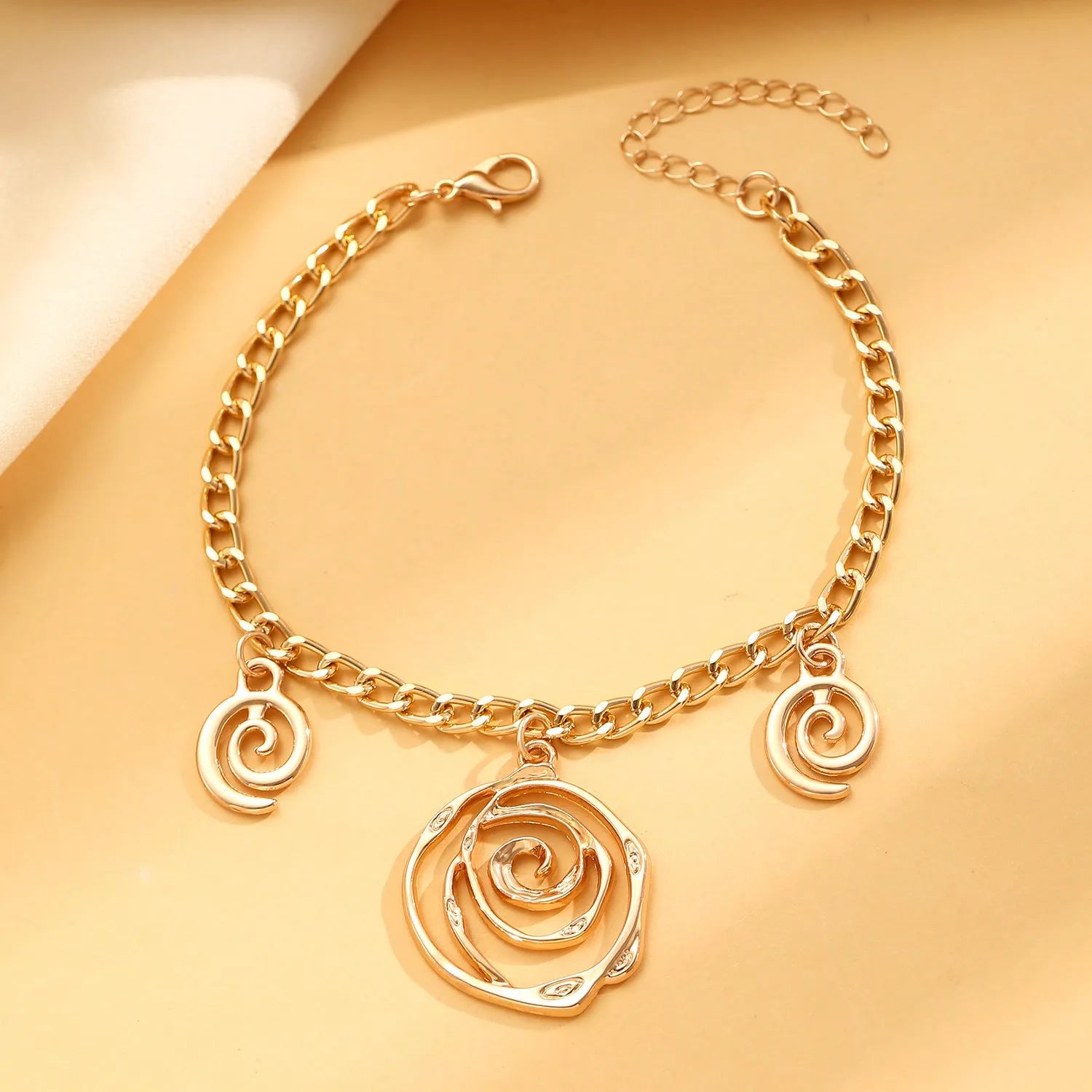 Women's spiral donut jewellery set showing matching gold necklace, bracelet, and earrings with geometric circle design