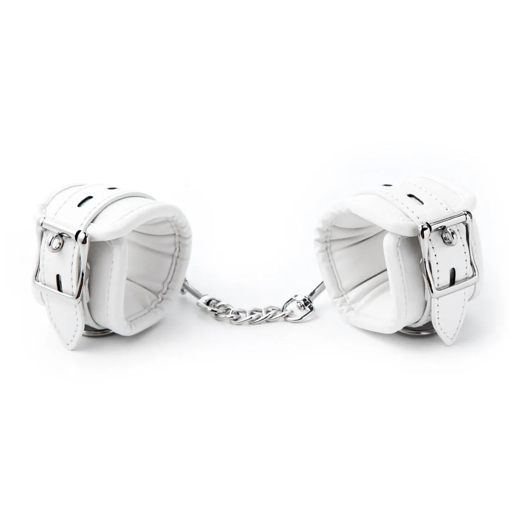 White PU sponge bondage set showing handcuffs, foot cuffs, and a neck cuff on a neutral background.