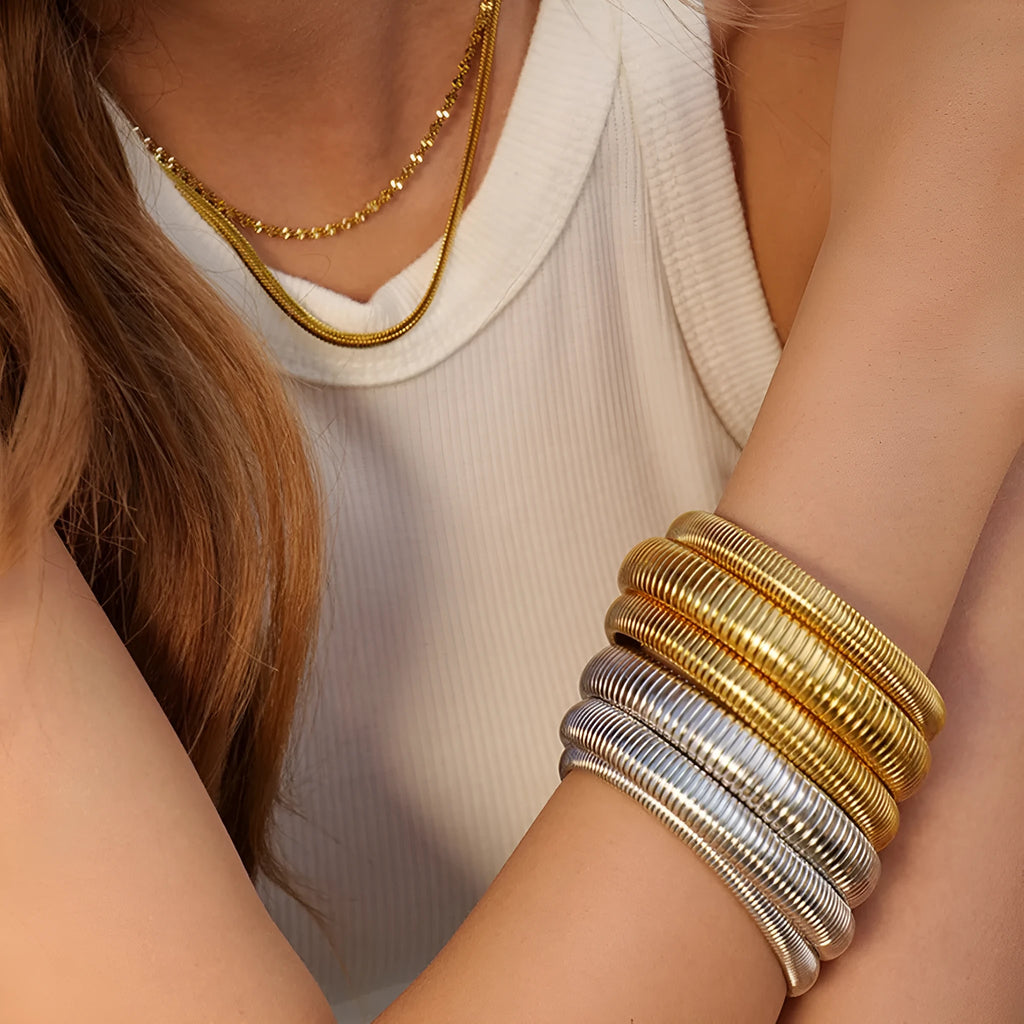 Women's vertical stripe elastic titanium steel bracelet in gold or silver finish with five width options