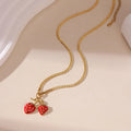 Close-up of a women's stainless steel strawberry pendant necklace on an alloy chain, showing red and white gradient colour options.