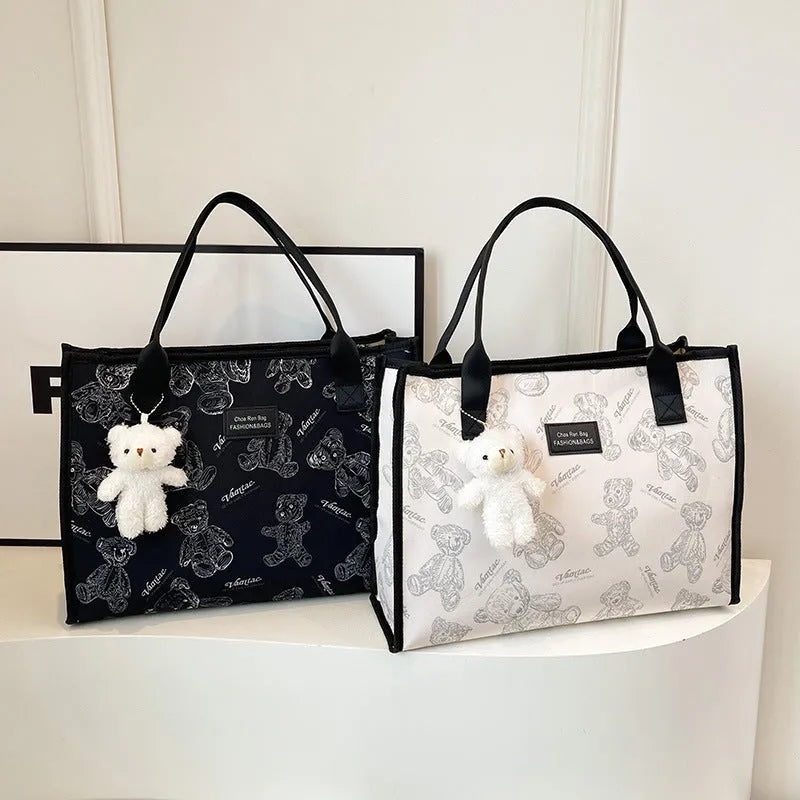 Women's printed canvas tote bag with large capacity, shown in black and white colour options with optional pendant