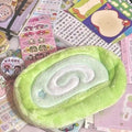 Honeydew Roll plush velvet pencil case with Swiss roll cake design on a desk.