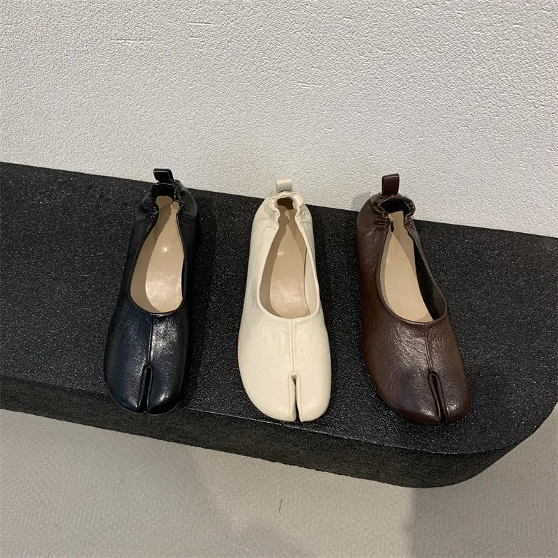 Women's black chunky heel pumps with round toe and split toe peas design on a rubber sole.
