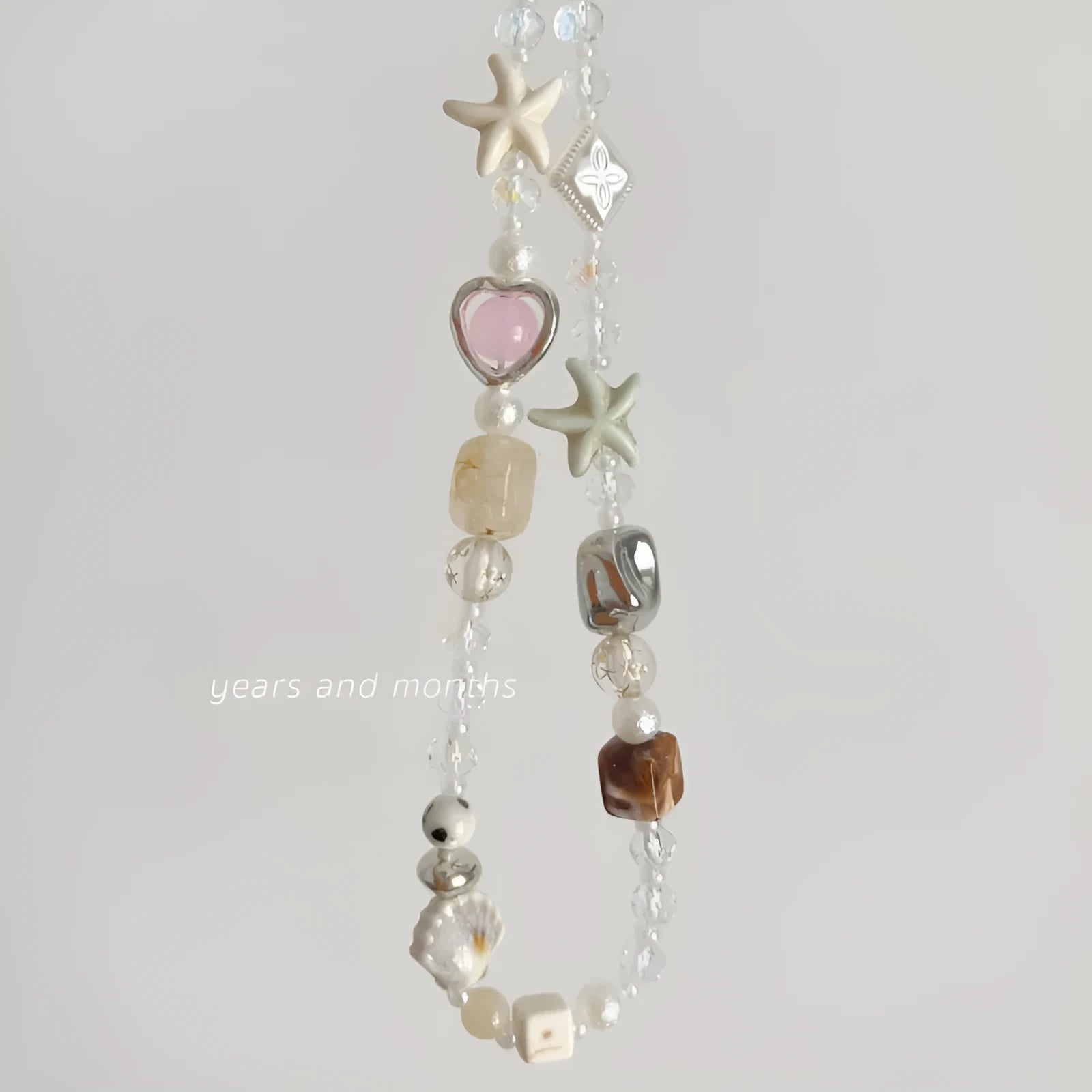 Island Sweetheart bohemian beaded alloy mobile phone charm on pastel background
