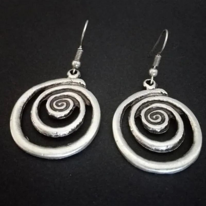 A pair of silver retro geometric spiral earrings with a distressed finish on a white background.