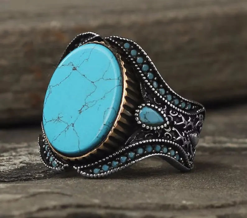 Men's turquoise and antique silver alloy ring on finger showing round band design with UK size markings