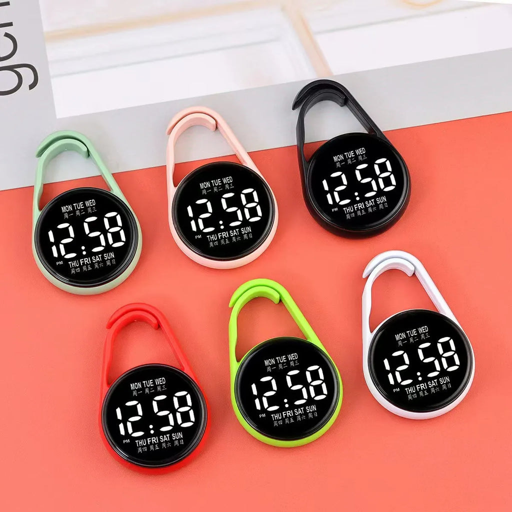 Mini digital electronic watch with luminous week display on a plastic strap, shown in multiple colour options.