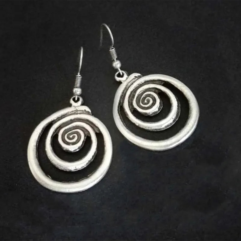 A pair of silver retro geometric spiral earrings with a distressed finish on a white background.