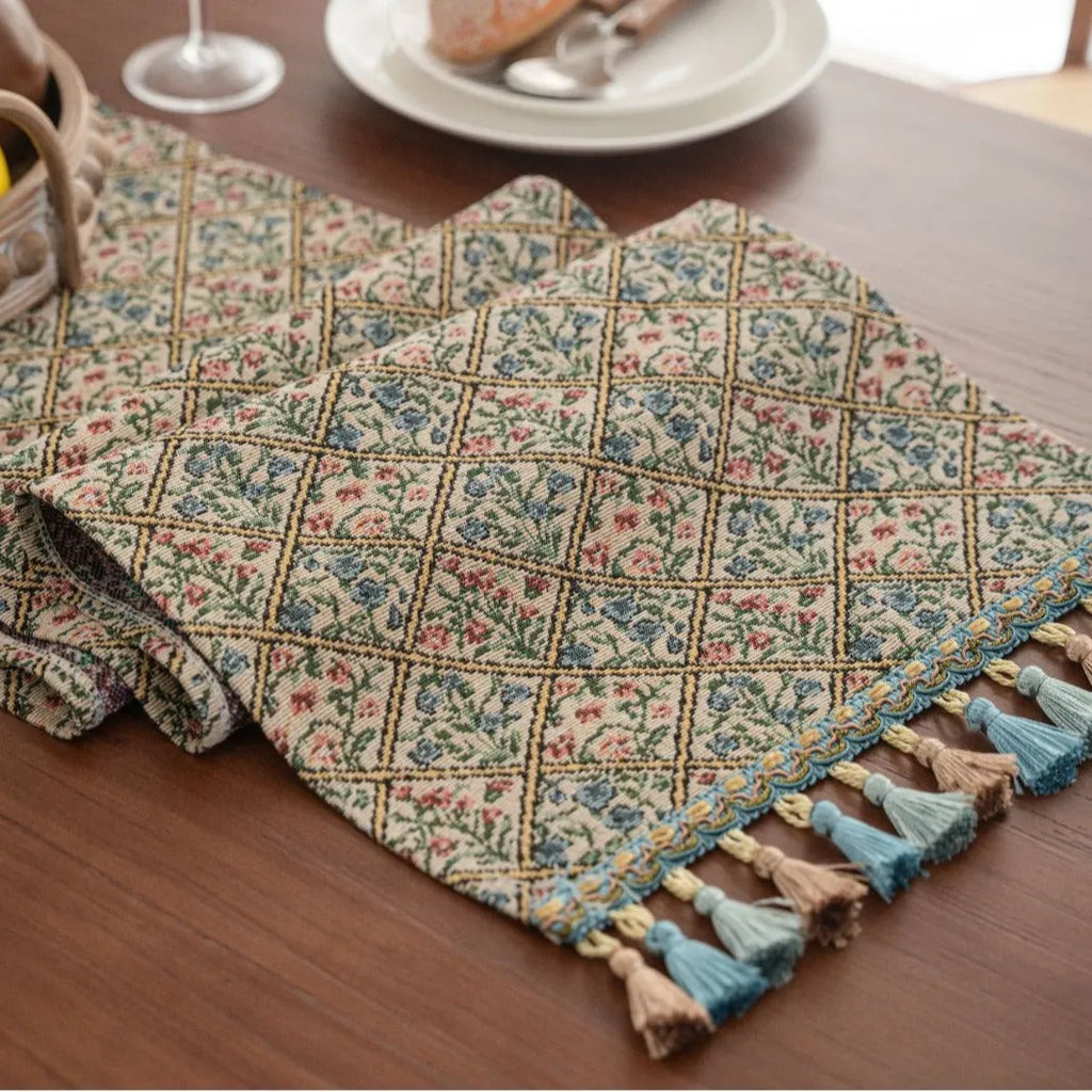 Dark blue striped Nordic style table runner with bouquet tassel decoration laid flat on a table.