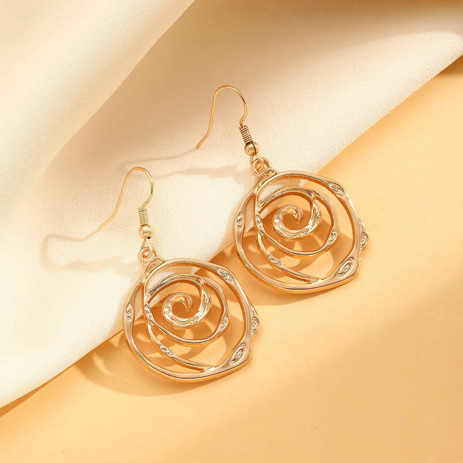 Women's spiral donut jewellery set showing matching gold necklace, bracelet, and earrings with geometric circle design