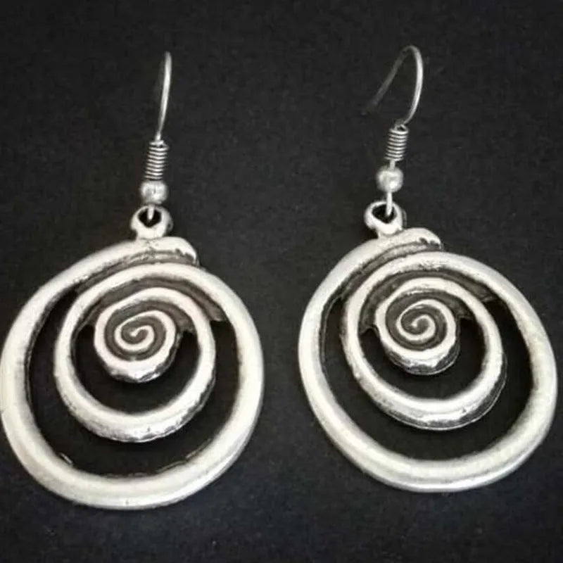 A pair of silver retro geometric spiral earrings with a distressed finish on a white background.