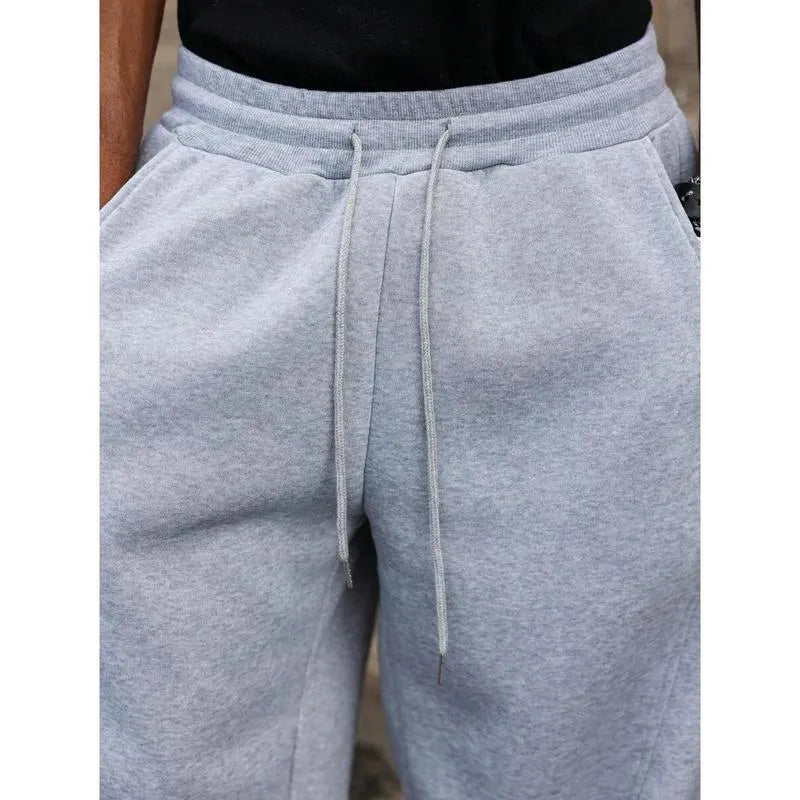 Man wearing dark grey high waist straight leg cropped casual trousers with an elasticated waistband.