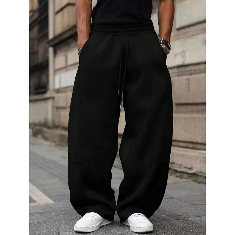 Man wearing dark grey high waist straight leg cropped casual trousers with an elasticated waistband.