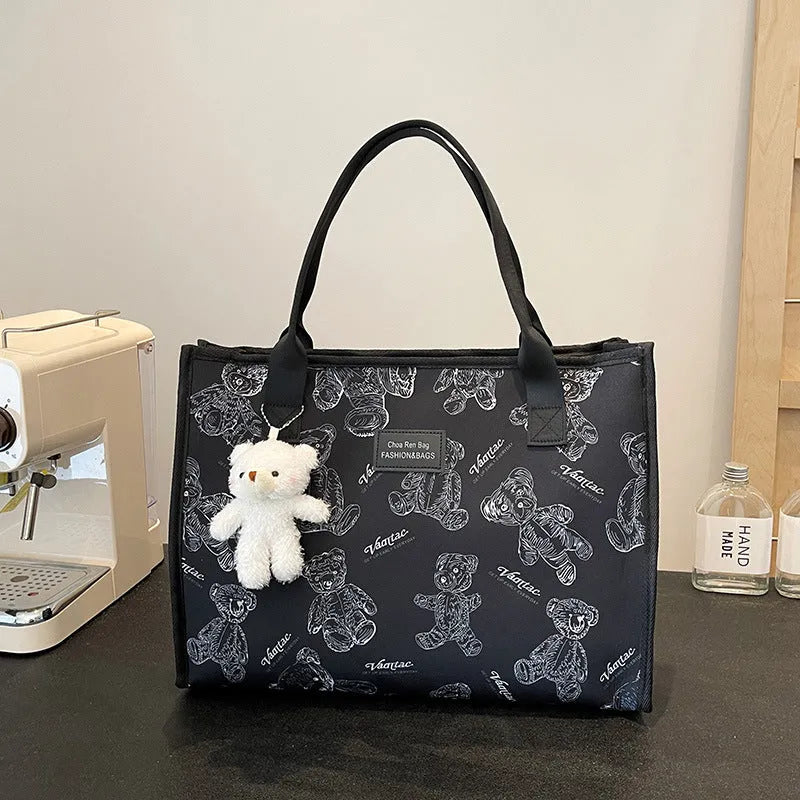 Women's printed canvas tote bag with large capacity, shown in black and white colour options with optional pendant