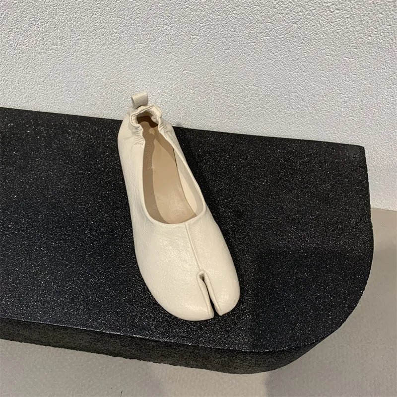 Women's black chunky heel pumps with round toe and split toe peas design on a rubber sole.