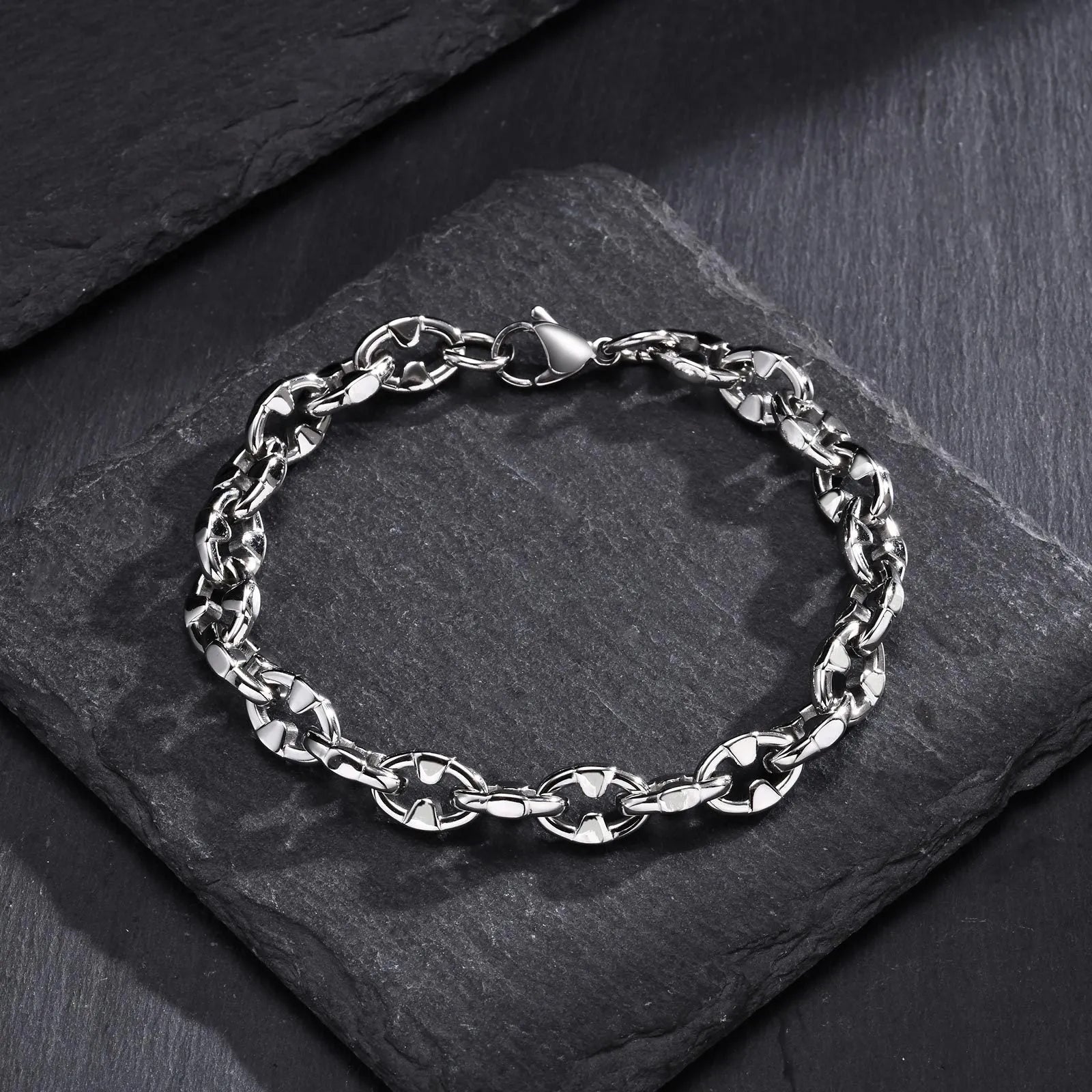 Men's stainless steel handmade geometric chain bracelet in steel colour on a wrist.