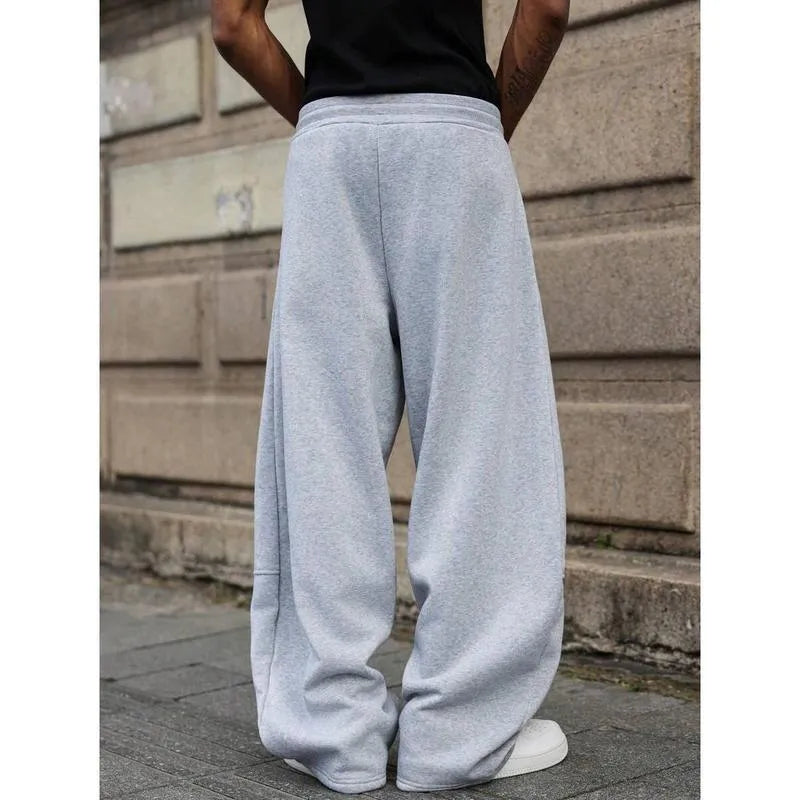 Man wearing dark grey high waist straight leg cropped casual trousers with an elasticated waistband.