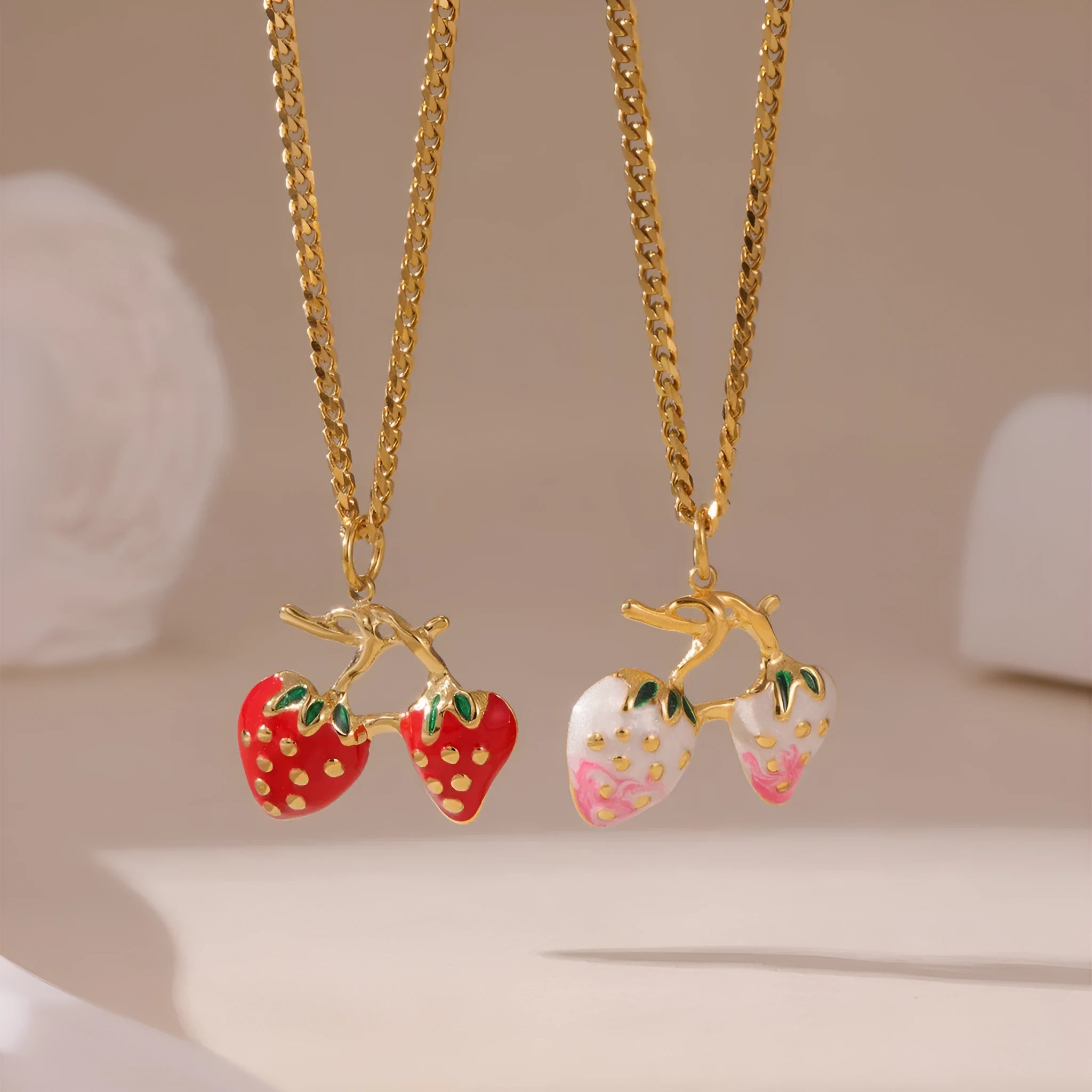 Close-up of a women's stainless steel strawberry pendant necklace on an alloy chain, showing red and white gradient colour options.
