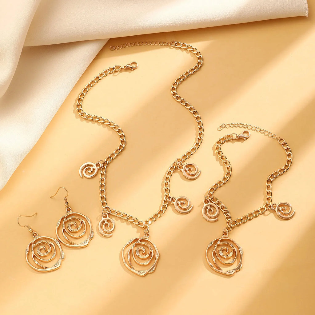 Women's spiral donut jewellery set showing matching gold necklace, bracelet, and earrings with geometric circle design