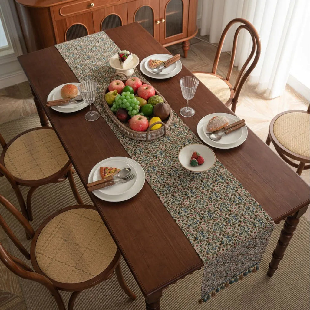 Dark blue striped Nordic style table runner with bouquet tassel decoration laid flat on a table.