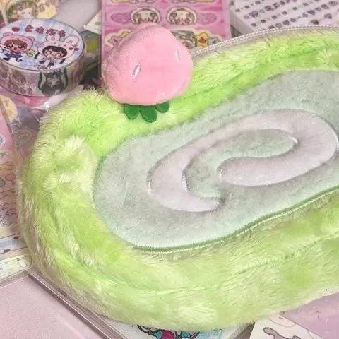 Honeydew Roll plush velvet pencil case with Swiss roll cake design on a desk.