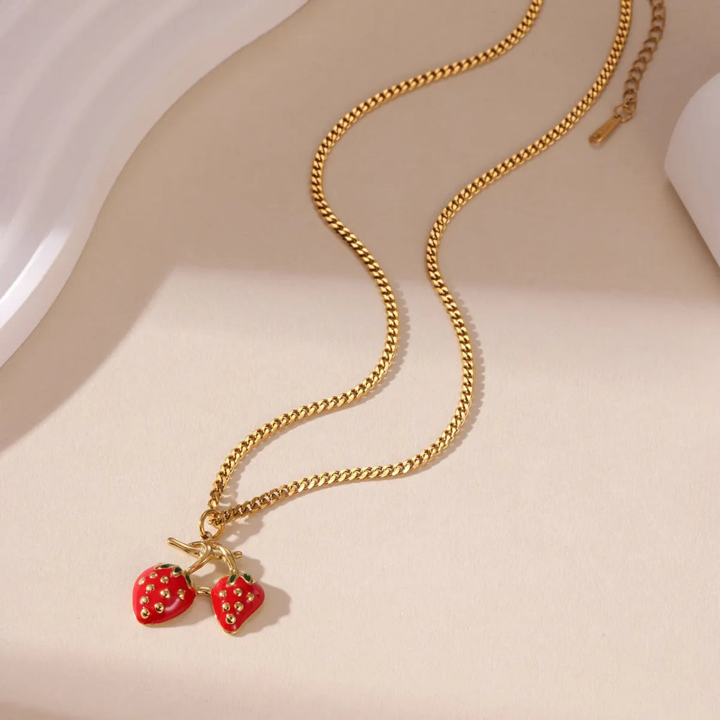 Close-up of a women's stainless steel strawberry pendant necklace on an alloy chain, showing red and white gradient colour options.
