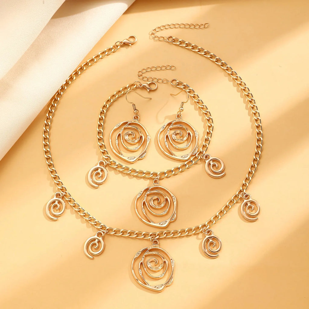 Women's spiral donut jewellery set showing matching gold necklace, bracelet, and earrings with geometric circle design