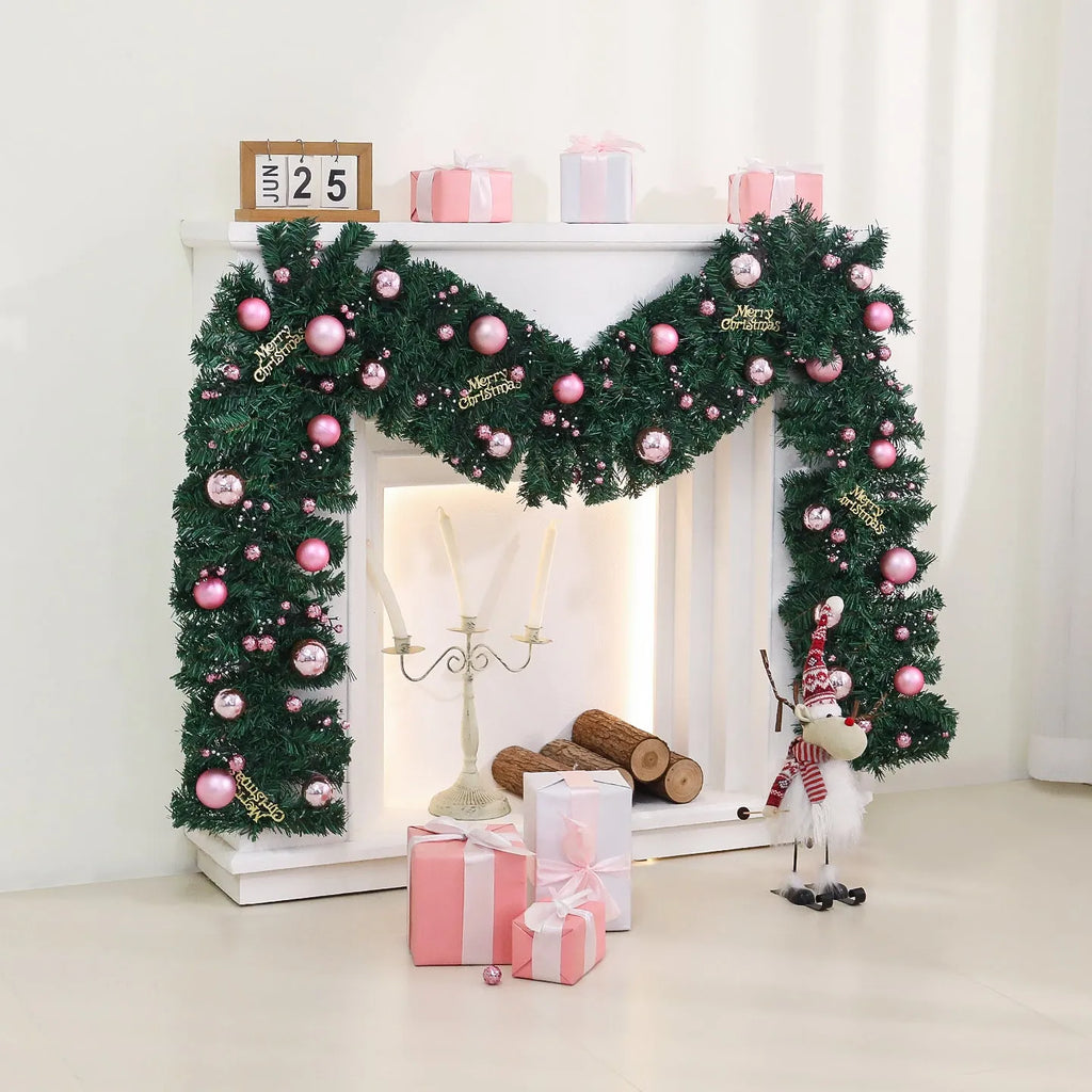 Long pink rattan Christmas wreath with small fruit decoration, shown draped on a door.