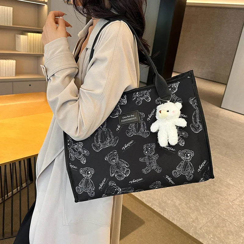 Women's printed canvas tote bag with large capacity, shown in black and white colour options with optional pendant