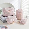 Four cube-shaped flannelette makeup bags in coordinated colours for travel organisation