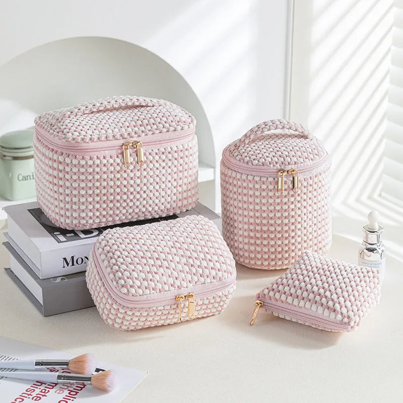 Four cube-shaped flannelette makeup bags in coordinated colours for travel organisation