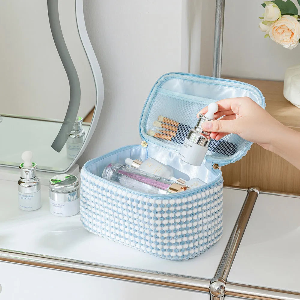 Four cube-shaped flannelette makeup bags in coordinated colours for travel organisation