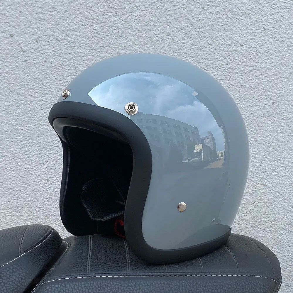 Retro-style open-face motorcycle helmet in glass fibre construction shown in a cement grey colour.