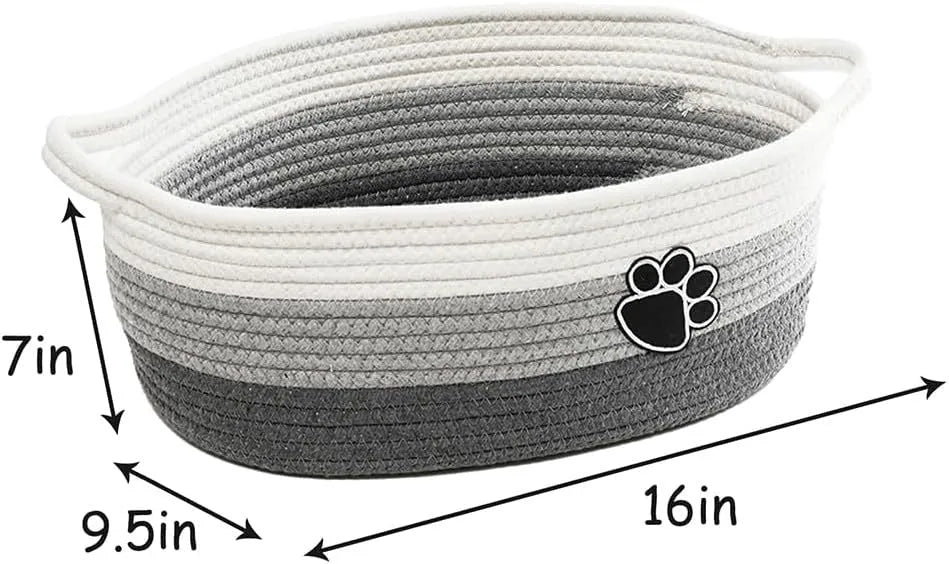 Small light beige woven cotton rope storage basket with handles on a wooden surface.