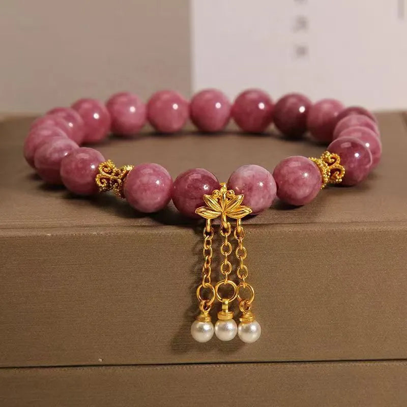 Natural stone beaded bracelet with pink lotus tassel and pearl pendant on white background