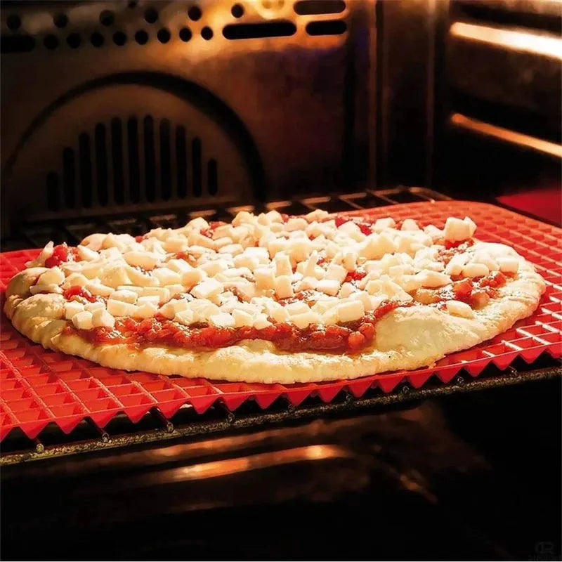 Red non-stick silicone pyramid cooking mat with grid on a baking tray for oven or BBQ use