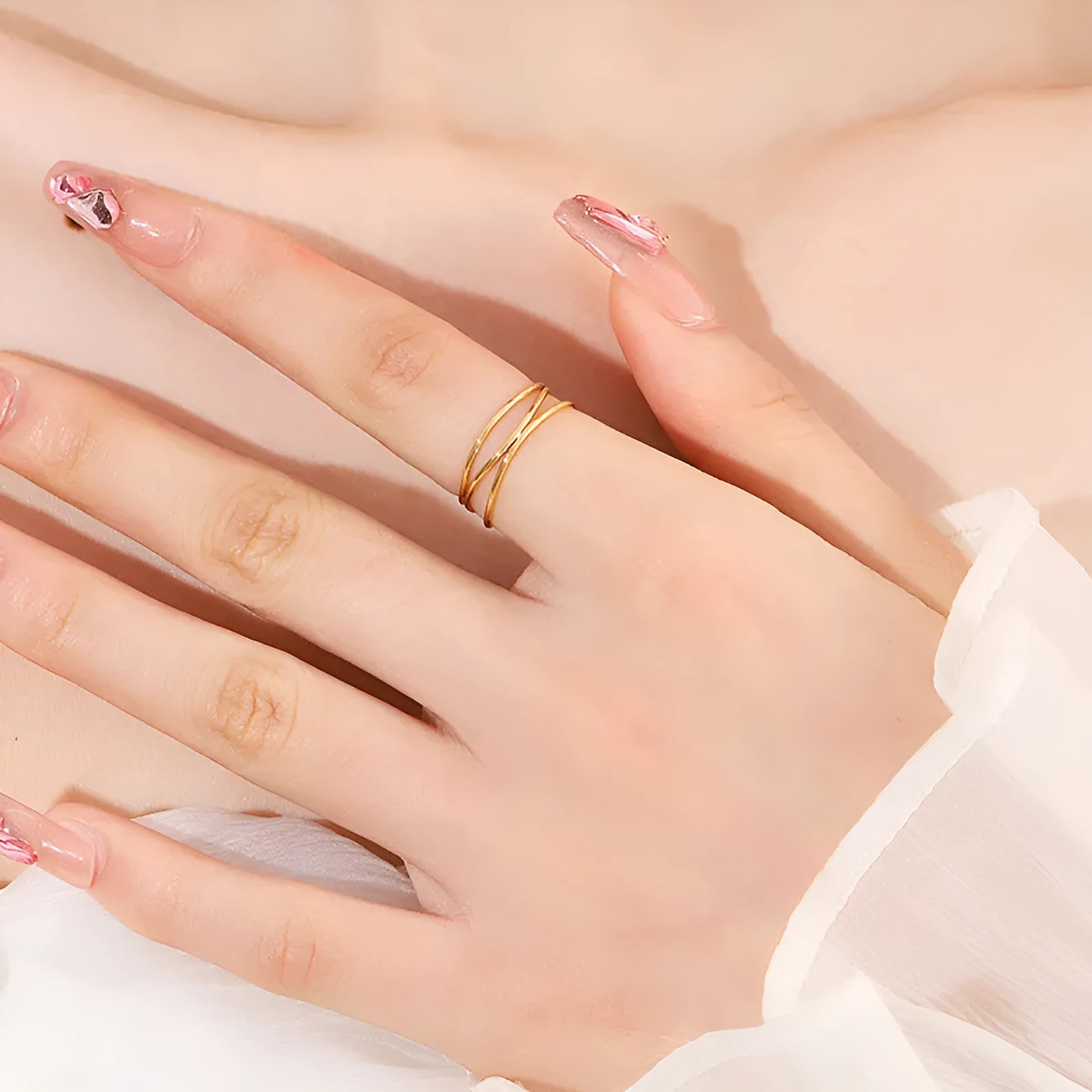 Gold geometric titanium steel ring with a three-layer coil design on a hand.