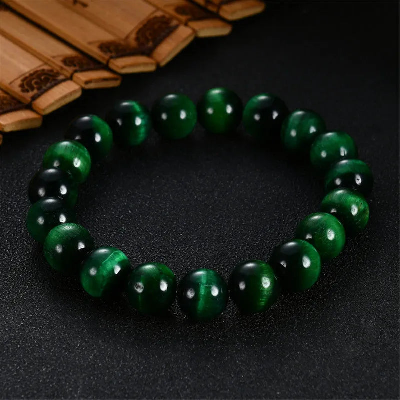 Green tiger eye stone bracelet with geometric polished beads showing banded natural patterns