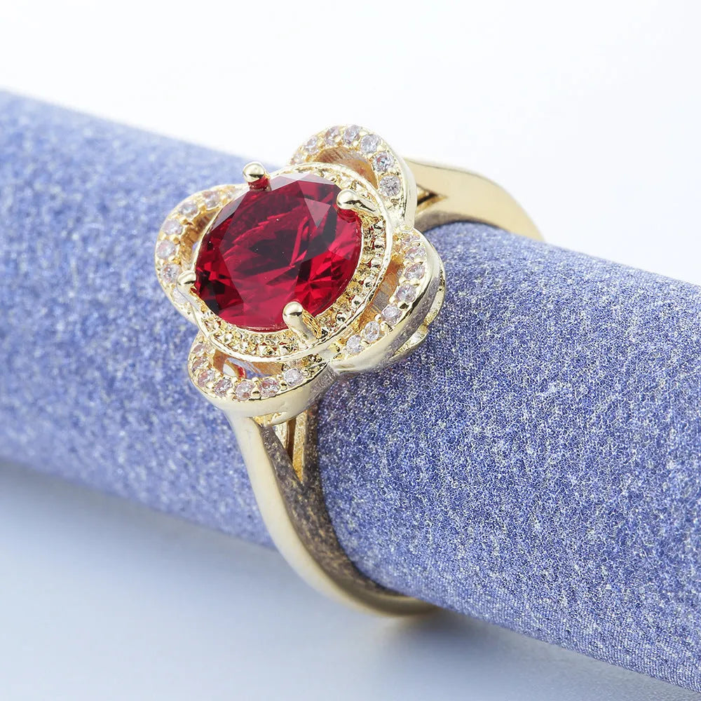 Close-up of a fruit-shaped copper ring with an electroplated finish and an inlaid zircon, shown on a hand.
