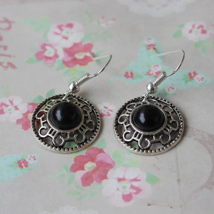 Handmade ethnic earrings with a Tibetan silver geometric flower disk design and turquoise stones.